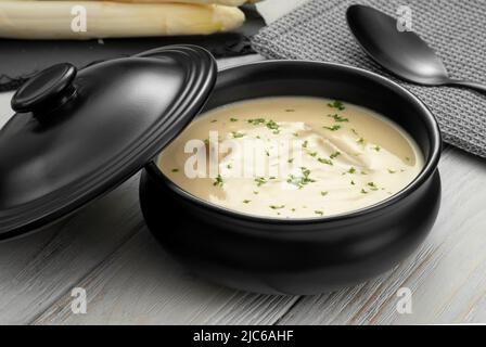 Délicieuse soupe à la crème d'asperges blanches sur fond de bois Banque D'Images