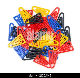 Trombones en plastique colorés isolés sur fond blanc, vue du dessus. Pinces à reliures triangulaires non métalliques rouge, jaune, bleu pour enfants Banque D'Images