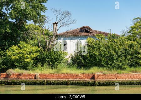 Maison abandonnée et cassée dans la lagune de Venise, partiellement cachée par la végétation. Venise, site classé au patrimoine mondial de l'UNESCO, Vénétie, Italie, Europe. Banque D'Images