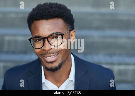 Photo d'un jeune homme noir très beau et positif avec une barbe souriante à l'extérieur Banque D'Images