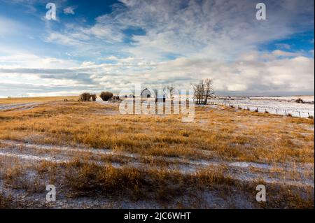 Une ferme de campagne abandonnée sous un ciel spectaculaire le matin sur les champs de blé canadiens dans le comté de Rockyview en Alberta Banque D'Images