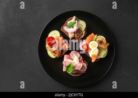 Vue de dessus des sandwiches danois sur une assiette noire Banque D'Images