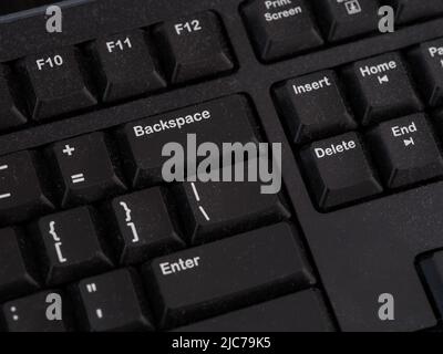 Un clavier d'ordinateur noir poussiéreux. Gros plan. Banque D'Images