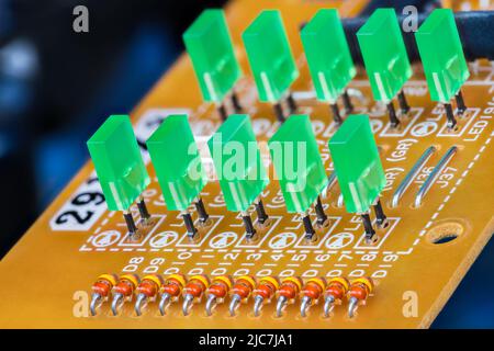 Petites diodes à semi-conducteurs orange et LED verte. Détail PCB sur fond flou foncé. Rangées de composants électroniques sous forme de diodes électroluminescentes rectangulaires. Banque D'Images