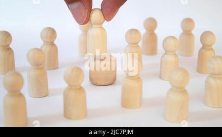 une main femelle tient une figurine en bois d'un homme sur la première étape de la pyramide. Développement personnel, chef de société, PDG, mentorat Banque D'Images