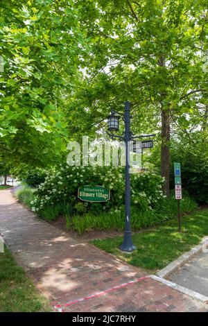 VILLAGE DE BILTMORE à ASHEVILLE, NC, USA-5 JUIN 2022: Panneau identifiant le village historique de Biltmore, entouré de feuillage. Panneaux de signalisation sur la barre de feux. Banque D'Images