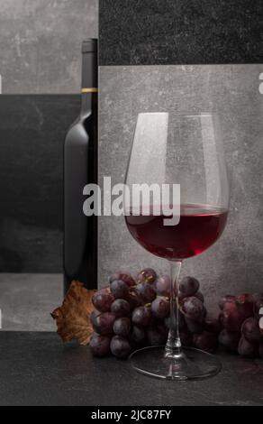 Vin rouge avec raisins et feuilles de vigne séchées. Copier l'espace. Banque D'Images