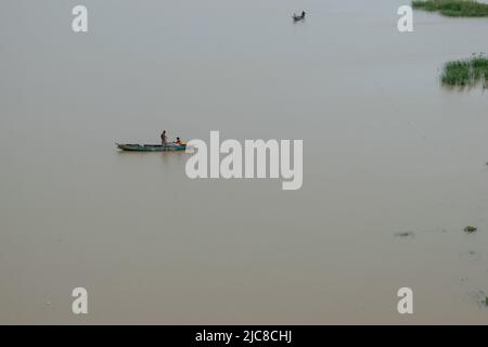 Petit bateau de pêche flottant seul sur l'eau calme en Inde. Banque D'Images