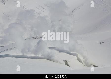 La vapeur s'élève du paysage volcanique enneigé Banque D'Images