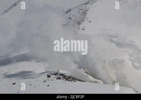 La vapeur s'élève d'un volcan actif dans une neige Banque D'Images