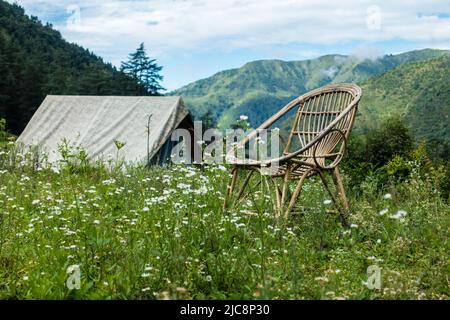 Un lieu touristique dans les prés avec un camp et une chaise en bambou avec des montagnes en arrière-plan. Uttarakhand Inde. Banque D'Images