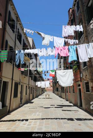 Vêtements traînant au soleil dans l'allée appelée CALLE sur l'île de VENISE en Italie en Europe du Sud Banque D'Images