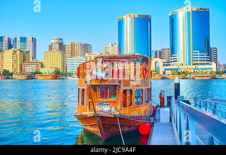 DUBAÏ, Émirats Arabes Unis - 1 MARS 2020 : Dubai Creek avec bateau de dhow d'époque, amarré à la banque du quartier d'Al Seef et des tours jumelles Deira modernes (tours Rolex) Banque D'Images