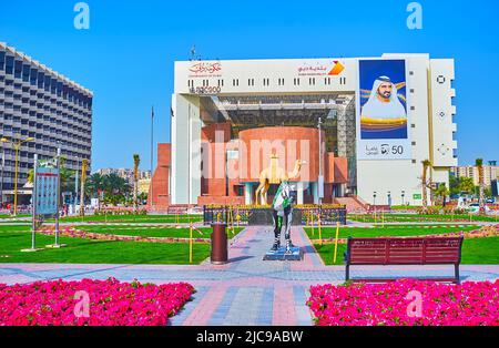 DUBAÏ, Émirats Arabes Unis - 1 MARS 2020 : les massifs fleuris du parc Creek Side en face des statues Camel et du siège de la municipalité de Dubaï, sur 1 mars à Dubaï Banque D'Images