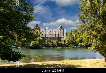 Turin, Piémont, Italie: Le Pô avec le château du Valentino (Castello del Valentino) parmi les arbres dans le parc sur la rivière et avec le ciel bleu et Banque D'Images