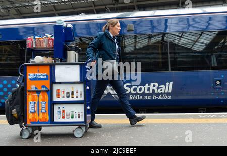 Édimbourg, Écosse, Royaume-Uni. 11 juin 2022. Les pénuries de conducteurs ont causé d'autres perturbations aux services ferroviaires exploités aujourd'hui par ScotRail à la gare Waverley d'Édimbourg. Bien que le différend avec les chauffeurs de train ASLEF semble avoir été résolu, il n'y a pas eu de retour à un service complet de train en Écosse. D'autres syndicats de la fonction publique prévoient désormais une action de grève en fonction des salaires et des conditions, ce qui pourrait entraîner d'autres perturbations en Écosse. Pic ; personnel avec un chariot à nourriture à la gare de Waverley. Iain Masterton/Alay Live News Banque D'Images