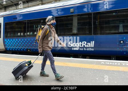 Édimbourg, Écosse, Royaume-Uni. 11 juin 2022. Les pénuries de conducteurs ont causé d'autres perturbations aux services ferroviaires exploités aujourd'hui par ScotRail à la gare Waverley d'Édimbourg. Bien que le différend avec les chauffeurs de train ASLEF semble avoir été résolu, il n'y a pas eu de retour à un service complet de train en Écosse. D'autres syndicats de la fonction publique prévoient désormais une action de grève en fonction des salaires et des conditions, ce qui pourrait entraîner d'autres perturbations en Écosse. Pic ; passagers à pied à bord des trains à la gare de Waverley. Iain Masterton/Alay Live News Banque D'Images