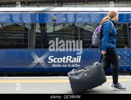 Édimbourg, Écosse, Royaume-Uni. 11 juin 2022. Les pénuries de conducteurs ont causé d'autres perturbations aux services ferroviaires exploités aujourd'hui par ScotRail à la gare Waverley d'Édimbourg. Bien que le différend avec les chauffeurs de train ASLEF semble avoir été résolu, il n'y a pas eu de retour à un service complet de train en Écosse. D'autres syndicats de la fonction publique prévoient désormais une action de grève en fonction des salaires et des conditions, ce qui pourrait entraîner d'autres perturbations en Écosse. Pic ; passagers à pied à bord des trains à la gare de Waverley. Iain Masterton/Alay Live News Banque D'Images