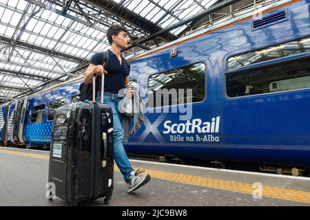 Édimbourg, Écosse, Royaume-Uni. 11 juin 2022. Les pénuries de conducteurs ont causé d'autres perturbations aux services ferroviaires exploités aujourd'hui par ScotRail à la gare Waverley d'Édimbourg. Bien que le différend avec les chauffeurs de train ASLEF semble avoir été résolu, il n'y a pas eu de retour à un service complet de train en Écosse. D'autres syndicats de la fonction publique prévoient désormais une action de grève en fonction des salaires et des conditions, ce qui pourrait entraîner d'autres perturbations en Écosse. Pic ; passagers à pied à bord des trains à la gare de Waverley. Iain Masterton/Alay Live News Banque D'Images