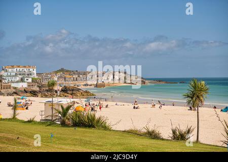 St Ives, Royaume-Uni. 11th juin 2022. Certaines parties du Royaume-Uni sont plus chaudes que le Portugal ou la Jamaïque. , Un train circule sur la pittoresque ligne de chemin de fer de St Ives Bay en passant par Lelant Beach en arrière-plan, en route vers St Ives crédit: kathleen White/Alay Live News Banque D'Images