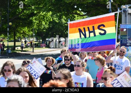 Les personnes qui prennent part au Portsmouth fierté 2022 mars tenue une bannière NHS. Banque D'Images