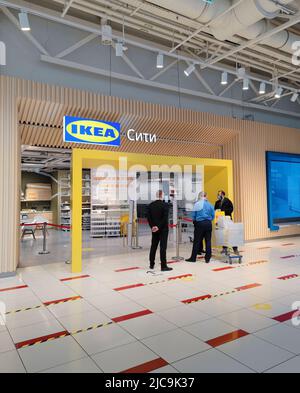 Moscou, Russie, 2022 mars : entrée au magasin IKEA. Les gardes parlent à un homme en noir avec des achats. À l'intérieur, vous pouvez voir des étagères avec des marchandises. Banque D'Images