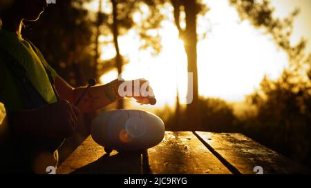 Femme jouant tambour de langue d'acier au coucher du soleil Banque D'Images