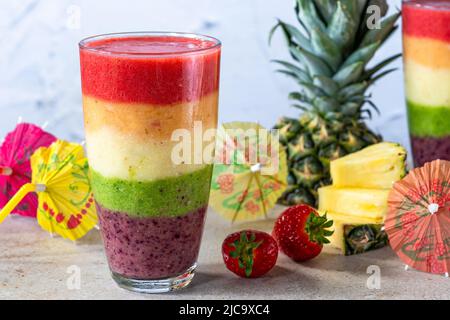 Smoothie coloré aux fruits bordés d'arc-en-ciel Banque D'Images