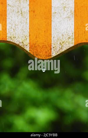 Pluie. Auvent sur un balcon et gouttes d'eau sur un fond naturel coloré pendant un jour de printemps Banque D'Images
