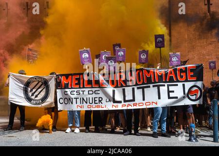 Photo de groupe avec les organisateurs de l'hommage, UAT Union Antifasciste Touloudaine, derrière une bannière, le meilleur hommage est de continuer à se battre! Ni l'oubli, ni le pardon et derrière des affiches avec portraits de victimes et de fumée jaune, rouge et noire, devant l'ancienne prison Saint-Michel de Toulouse. Hommage à Clément Méric devant l'ancienne Maison d'arrêt St Michel à Toulouse, activiste antifasciste, est mort sous les coups d'une tête de peau extrême droite sur 05 juin 2021 à Paris. France, Toulouse le 11 juin 2022. Photo de Patricia Huchot-Boissier/ABACAPRESS.COM Banque D'Images