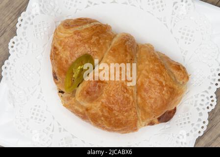 Vue en hauteur d'un savoureux sandwich au jambon au four et au fromage jalapeno croissant de la boulangerie servi sur une assiette. Banque D'Images