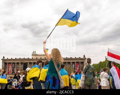 Berlin, Berlin, Allemagne. 11th juin 2022. Une femme porte un drapeau ukrainien à Granitschale im Lunstgarten à Berlin, en Allemagne, lors d'un rassemblement de réfugiés et de partisans ukrainiens. Samedi, 11 juin 2022. (Credit image: © Dominic Gwinn/ZUMA Press Wire) Banque D'Images