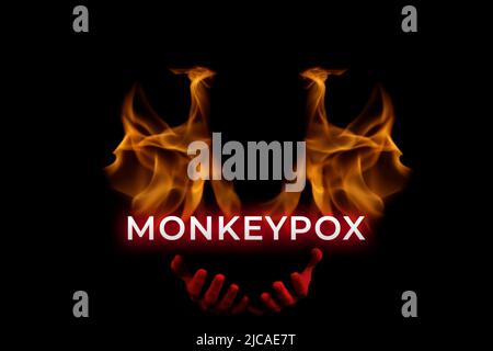 Défocus le virus de la monkeypox de mot. Une silhouette d'homme contre le fond des flammes et du feu s'étire les mains rouges dans le sang. Mendient et demande. Abandonnez Banque D'Images