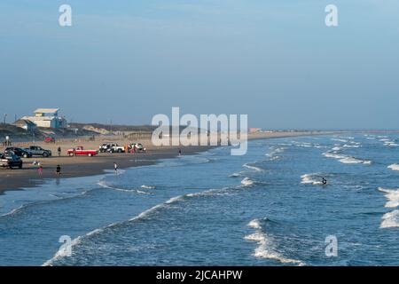 PORT ARANSAS, TX - 17 FÉVRIER 2020 : familles et touristes appréciant la plage lors d'une soirée hazante au Golfe du Mexique au Texas. Les voitures et les pick-up sont Banque D'Images