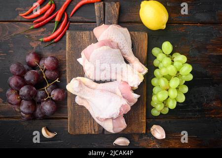 Ingrédients de surprise au poulet sucré, avec raisin et persil, sur planche à découper en bois, sur une vieille table en bois sombre, vue de dessus plate Banque D'Images
