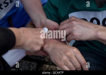 Londres, Royaume-Uni. 11th juin 2022. Les professionnels de la santé ont vu des manifestants se décoller les mains. Les professionnels de la santé se sont encollés à l'extérieur de Downing Street pour protester contre le soutien financier et réglementaire des combustibles fossiles par le gouvernement britannique. Crédit : SOPA Images Limited/Alamy Live News Banque D'Images