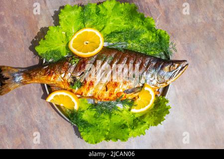 Poisson rouge grillé saumon rose avec citron et herbes. Cuisson de délicieux aliments sains. Banque D'Images