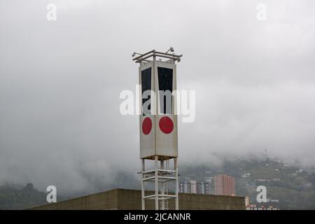 Point d'exclamation noir et rouge sur un bâtiment en un jour nuageux Banque D'Images