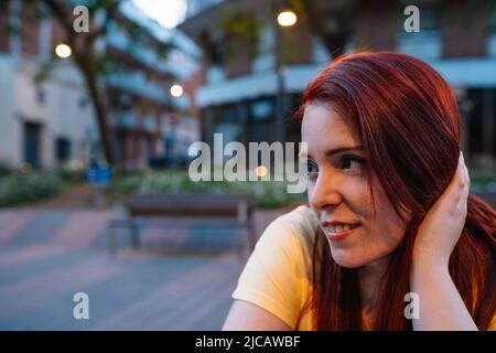 portrait d'une jeune fille assise sur la terrasse d'un bar dans la ville le soir. femme profitant de son temps libre. concept de vie nocturne et de fête. Banque D'Images