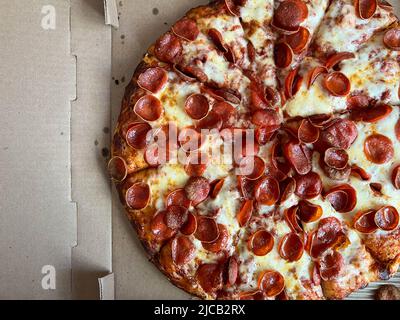 Pizza Pepperoni entière livrée dans une boîte en carton Banque D'Images