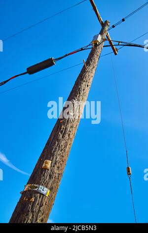 Vue sur le poteau téléphonique de ligne électrique avec un ciel bleu vif Banque D'Images