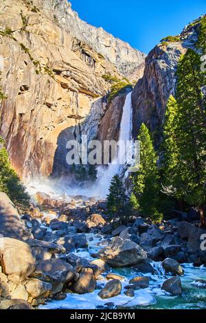 Petit arc-en-ciel par les chutes dépolies de Yosemite Lower Falls au début d'avril Banque D'Images