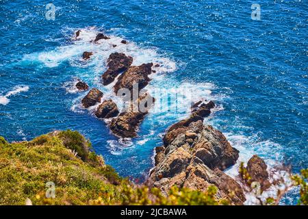 Vue sur l'océan depuis les falaises avec des rochers et des vagues qui s'écrasant Banque D'Images