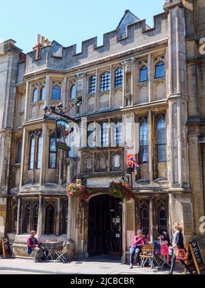 Clients assis à l'extérieur de l'hôtel médiéval George and Pilgrims à Glastonbury, Somerset, Angleterre, Royaume-Uni. Banque D'Images