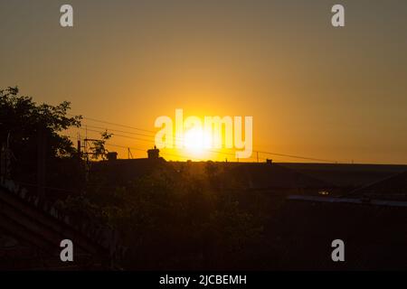 le ciel du matin au-dessus d'un village au soleil brille sur les toits des maisons Banque D'Images