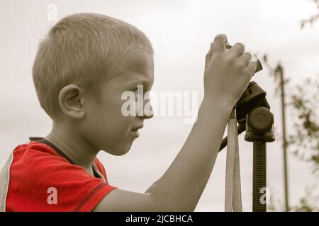 Petit garçon avec un nouvel appareil photo en plein air. Banque D'Images
