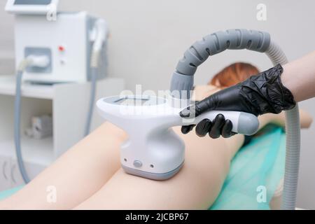 Photo rognée d'esthéticienne utilisant une machine de massage endosphere sur les cuisses du client, traitement anti-cellulite et amincissement. Massage du drainage lymphatique dans un salon de beauté Banque D'Images