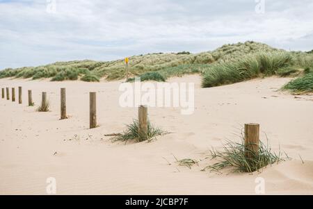 Des poteaux en bois sur la plage d'Ainsdale marquent le périmètre du parking utilisé par le public. Banque D'Images