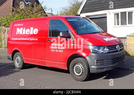 Les ingénieurs ont Red Volkswagen VW Miele van pour les appareils domestiques et professionnels en mettant le service clientèle en stationnement sur la route résidentielle Essex Angleterre Royaume-Uni Banque D'Images