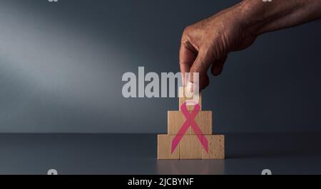 ruban de sensibilisation au cancer sur des blocs de bois sur fond gris bleu , concept du mois national de contrôle du cancer . Banque D'Images